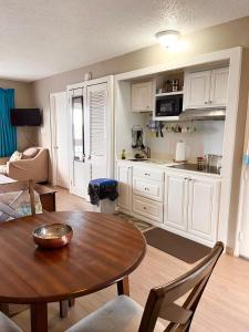 ein Wohnzimmer mit einem Tisch und einer Küche in der Unterkunft Point Village in Negril