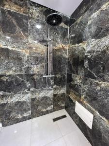 a bathroom with a shower with a stone wall at Résidence plage Oued Tanger in Skikda