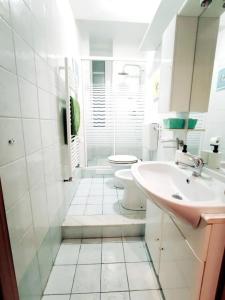 a white bathroom with a toilet and a sink at La Casetta di Hera by SMART-HOME in Genoa