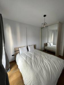 a bedroom with a white bed and a mirror at Iris Luxury Apartment in Ioannina