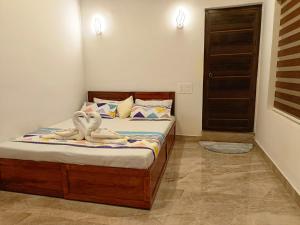 a bedroom with a bed with towels on it at Paradise Single Room in Wayanad