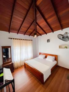 1 dormitorio con cama y techo de madera en Hotel Classio, en Digana