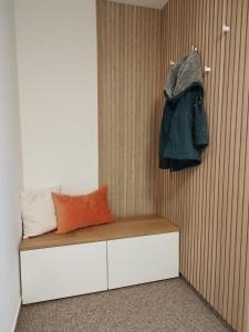 a bed with a jacket hanging on a wall at Schlossblick - Modernes & zentrales Apartment mit Balkon und Arbeitsplatz in Schwerin