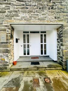 an entrance to a stone building with a white door at The Old Salt House, Flat 2 in Wick