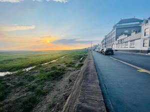 a street with cars parked on the side of the road at The Rambler's Rest Cottage, Parkgate, Wirral in Parkgate