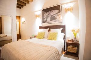 Un dormitorio con una cama grande con dos almohadas amarillas. en MALAVER SUITE, en Sevilla