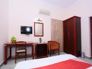 a bedroom with a desk and a mirror and a bed at karthika residency in Cochin