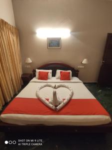 a bedroom with a bed with a heart on it at karthika residency in Cochin