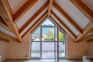 a room with a large window in a attic at La casa di Terlago in Terlago