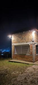 un edificio de ladrillo con ventana por la noche en Čaroban pogled, en Srebrenik