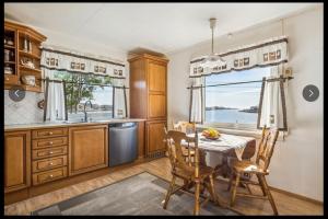 a kitchen with a table and chairs and a window at Skipperhuset in Sund