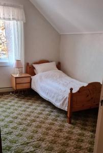 a bedroom with a bed and a table and a window at Skipperhuset in Sund