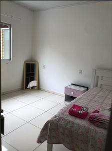 a white bedroom with a bed and a fireplace at casa de praia in Navegantes