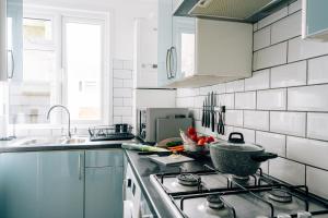 a kitchen with a stove and a sink at Sanctuary-by-Sea in Worthing