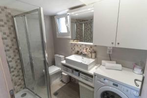 a bathroom with a sink and a washing machine at Studio Anna in Káto Garoúna +32 photos