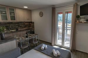 a kitchen with a table and a kitchen with a balcony at Studio Anna in Káto Garoúna