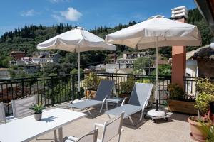 a patio with tables and chairs and umbrellas at Studio Anna in Káto Garoúna