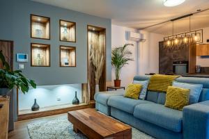 un salon avec un canapé bleu et une table dans l'établissement Appartement Cosy Jardin et Terrasse, à Strasbourg 17 autres photos