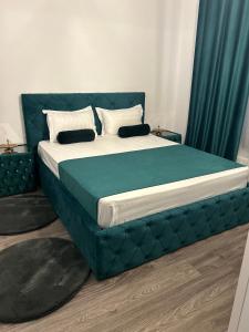 a bedroom with a large bed with a blue headboard at Pensiunea Le Patrick in Afumaţi