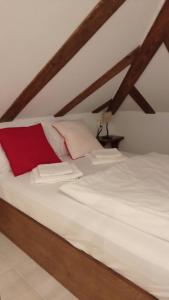 a bedroom with a white bed with a red pillow at Dominique House Meteora in Kalabaka