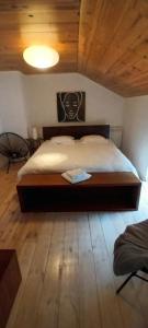 Un dormitorio con una cama grande con suelo de madera. en Maison-indi deluxe 3 slpk-6p, en Houffalize