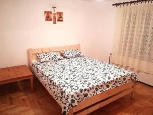 1 dormitorio con 1 cama con edredón blanco y negro en Rajski metoh en Kosjerić