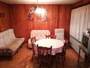 comedor con mesa, sillas y sofá en Rajski metoh en Kosjerić