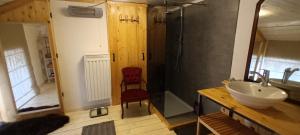 baño con lavabo y silla roja en Maison-indi deluxe 3 slpk-6p, en Houffalize 6 fotos más