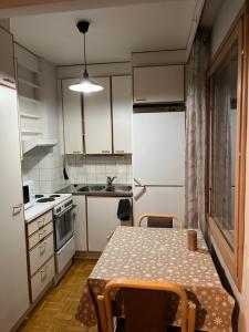 uma pequena cozinha com uma mesa e um frigorífico em Apartment Ahkio North em Rovaniemi