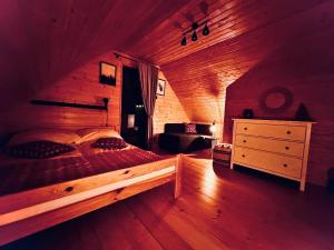 1 dormitorio con 1 cama grande en una habitación de madera en Przystanek Śnieżka, en Kowary