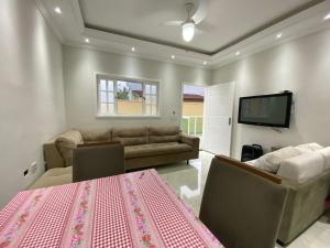 sala de estar con sofá y TV en morada do sol, en Ubatuba