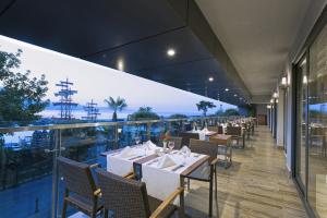 een restaurant met tafels en stoelen en uitzicht op de oceaan bij Hotel Kaptan in Alanya