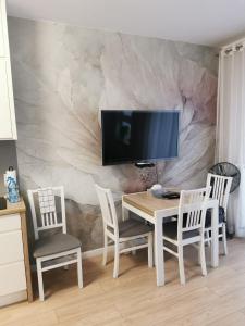 グダニスクにあるStudio Słoneczneのダイニングルームテーブル(椅子付)、壁掛けテレビ