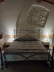 1 dormitorio con 1 cama con 2 mesitas de noche y 2 lámparas en Il Vicolo House, en Santa Rufina