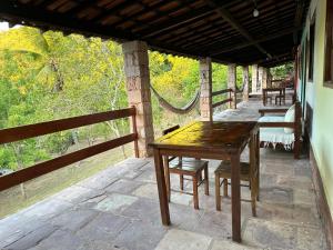 Une table et des chaises en bois sont disponibles sur la terrasse. dans l'établissement Encanto do Parque Hospedagem, à Lençóis