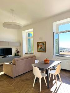 Una sala de estar con un sofá, una mesa y sillas. en Alocasia luxury stay, en Salerno