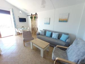un soggiorno con divano e tavolo di Apartamento Valle del Guadiaro a Cortes de la Frontera