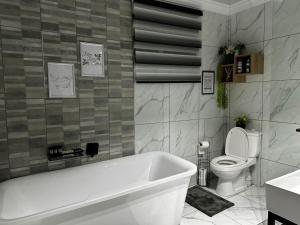 uma casa de banho com uma banheira branca e um WC. em Acuvea Inn em Kempton Park