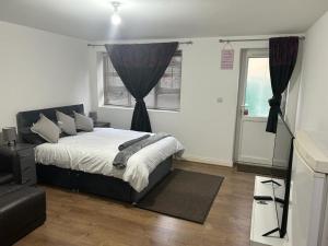 a bedroom with a bed and a window at Hometel Nice Cute Apartment in Thornton Heath