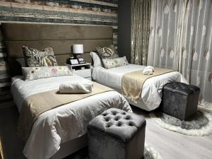 sypialnia z 2 łóżkami i otomaną w obiekcie Acuvea Inn w mieście Kempton Park