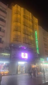 a large building with yellow lights on it at night at GUEST INN HOTEL in Dubai