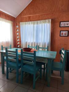 una mesa de comedor y sillas con una mesa azul y una ventana en Casa Conguillio en Melipeuco, en Melipeuco