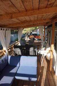 a porch with a couch and chairs on a deck at DM mobile home in Jezera