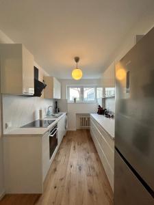 uma cozinha com electrodomésticos brancos e piso em madeira em Sweet Home in Meerbusch em Meerbusch