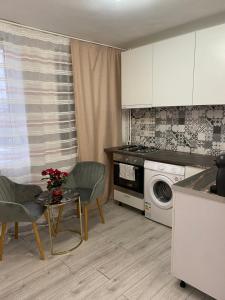 een keuken met een tafel en een wasmachine bij Sofi Studio Central in Boekarest