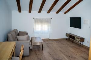 een woonkamer met een bank en een tv bij Casa Nueva Caravaca in Caravaca de la Cruz