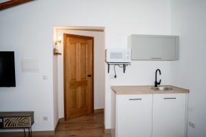 a white kitchen with a sink and a door at Casa Nueva Caravaca in Caravaca de la Cruz