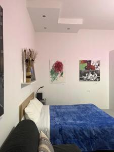 a bedroom with a bed with a blue comforter at Casa Cirenaica Art House in Bologna