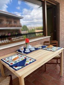 a wooden table with two plates of food on a balcony at Green & relax near S.Peter in Rome