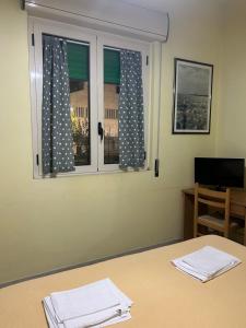 a room with a table and a window with polka dots at Albergo pensione Bianco in San Giovanni Rotondo